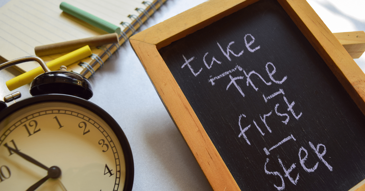 A chalkboard with the handwritten message "take the first step