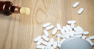 Alcohol and Adderall pills on table