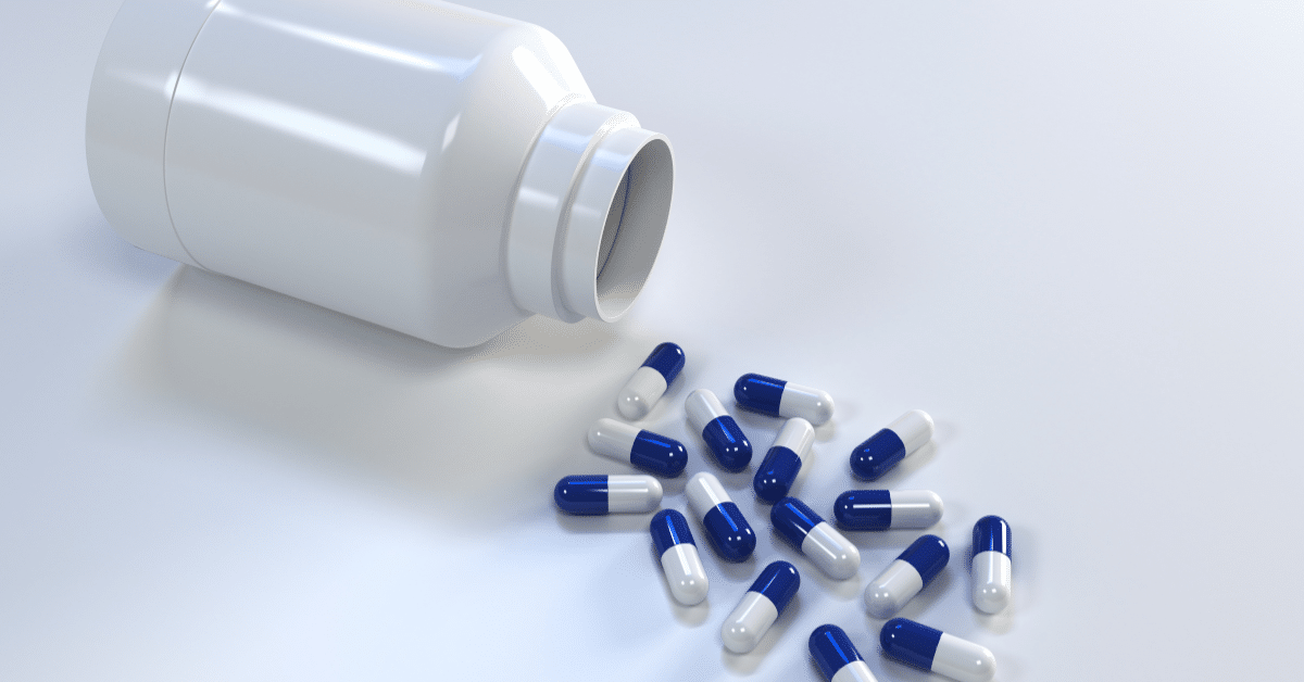 Prescription pills spilling from a white bottle