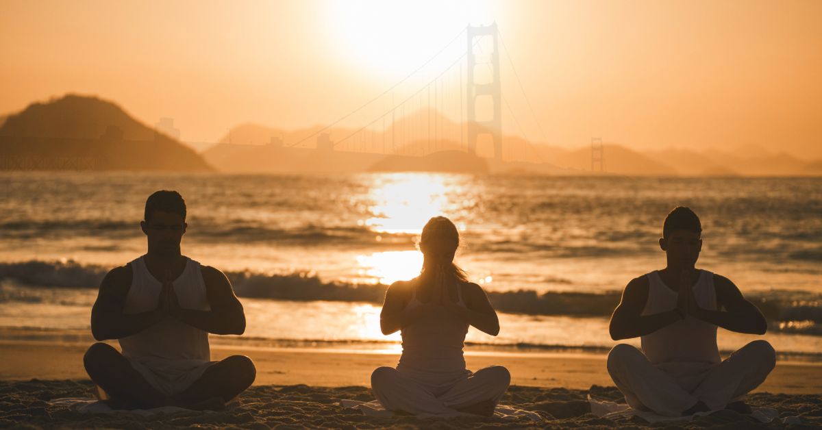 People meditating at sunset
