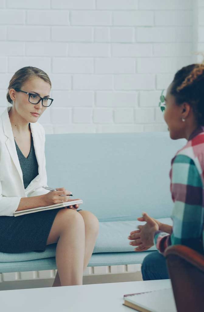 Counselor taking notes during a one-on-one session with a client