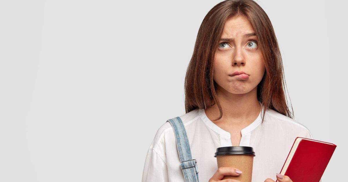 Confused woman holding coffee and notebook