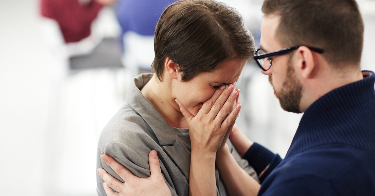 Person crying while receiving emotional support