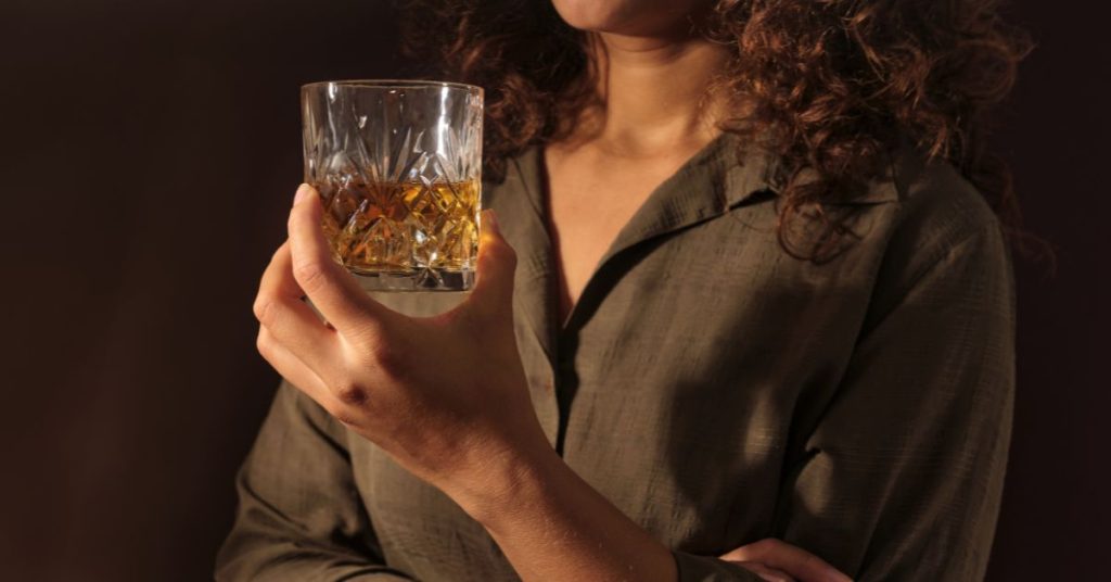 Person holding a glass of whiskey