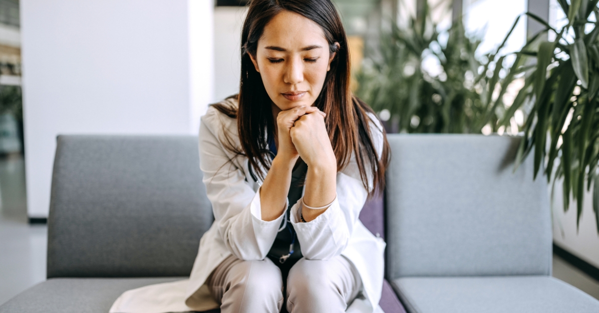 Exhausted woman sitting with head bowed