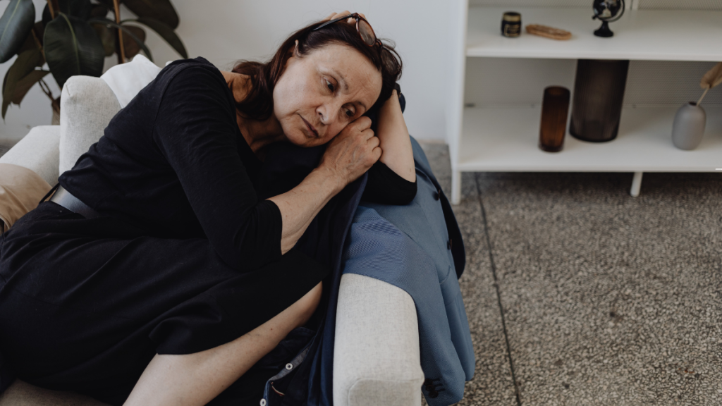 Woman sitting on a couch looking emotionally exhausted